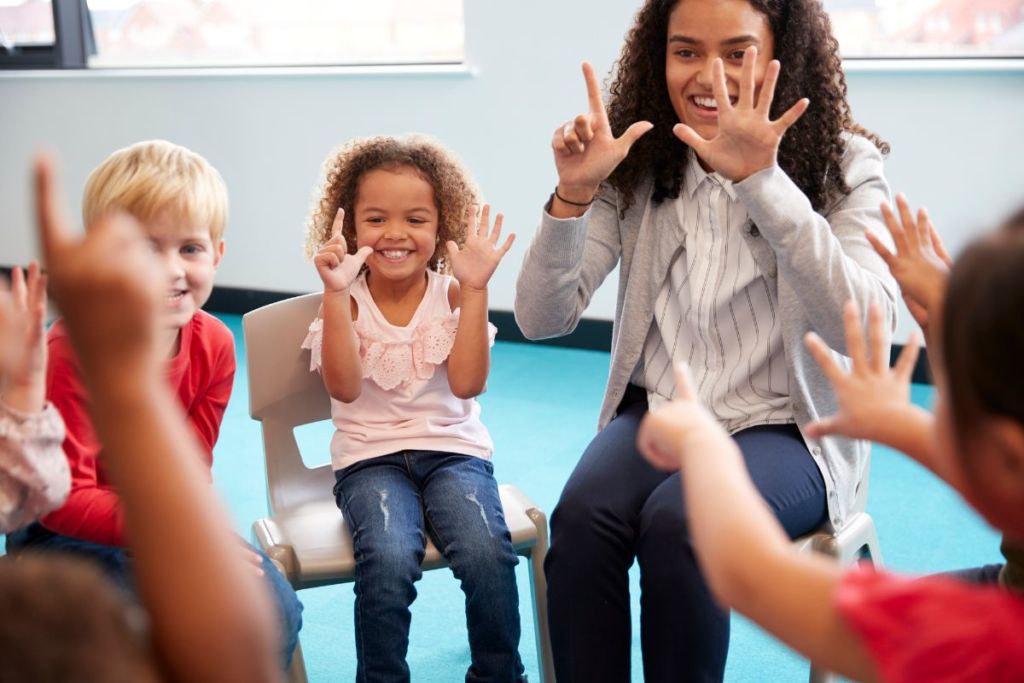 a teacher in a circle with a group of students practicing counting