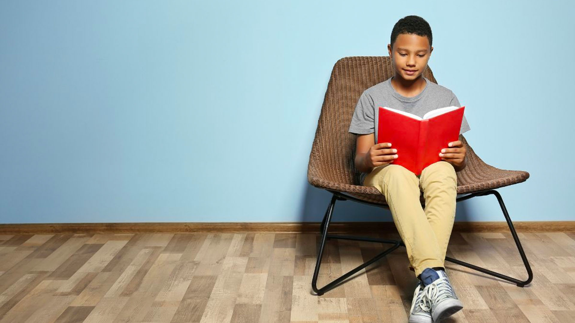 kid reading a book while sitting on a chair
