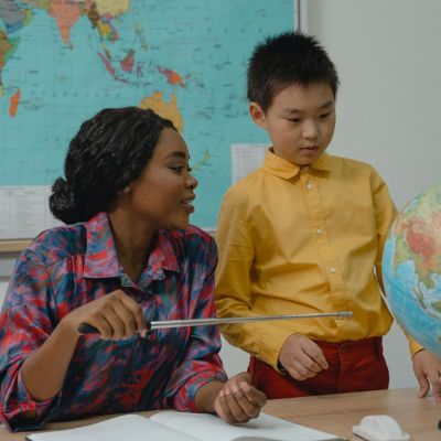 teacher and student looking at a globe
