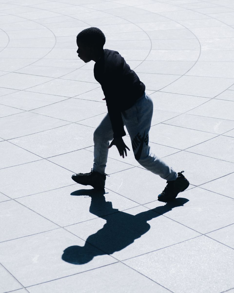 child walking next to his shadow