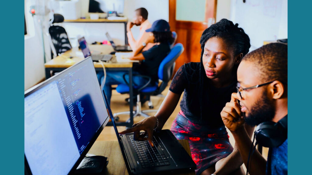 teacher helping student on a computer