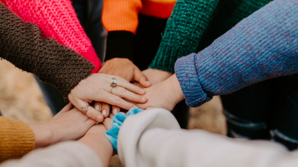 hands on top of each other together in a circle