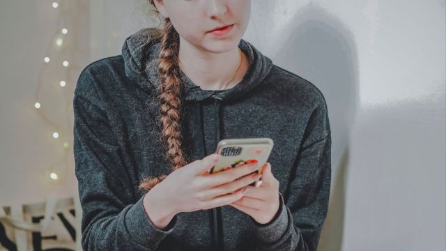 teenager holding and using a phone
