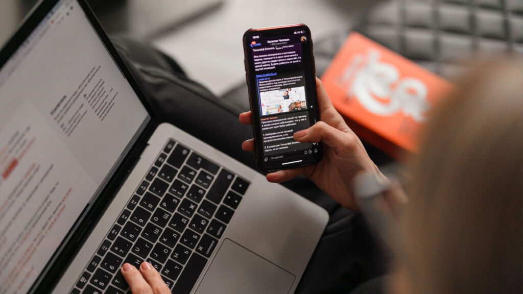 person using computer and phone