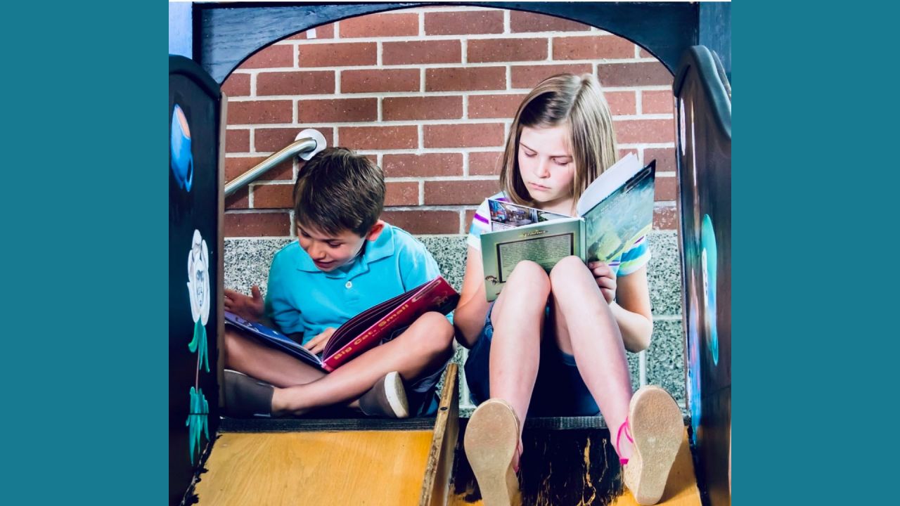 children reading on a slide