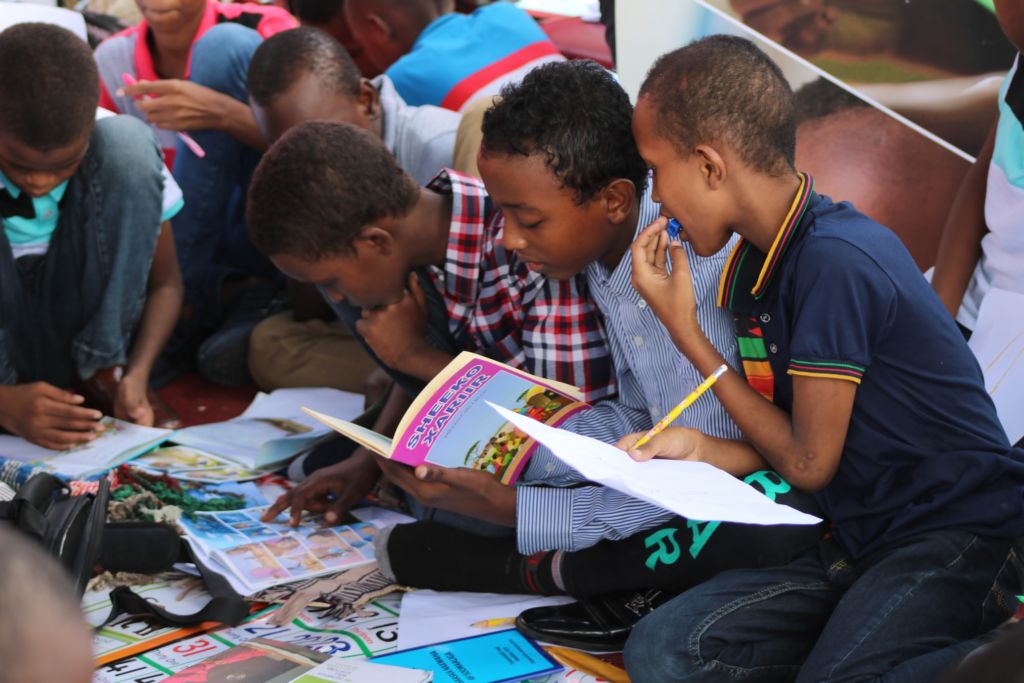 young boys working in workbooks together