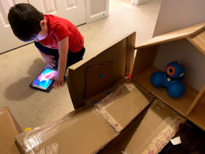 child working on tablet and building
