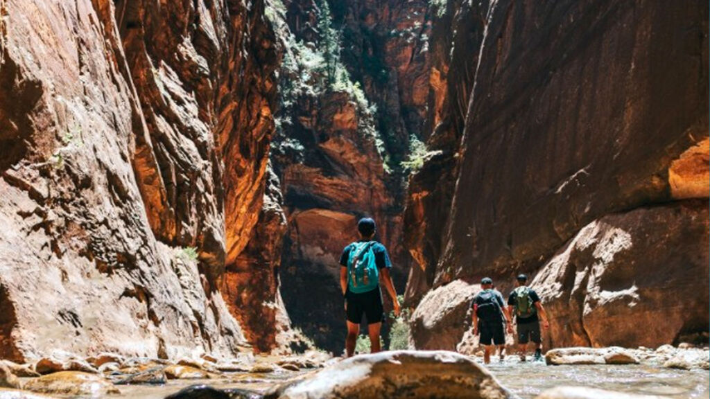 stream running through a canyon with people