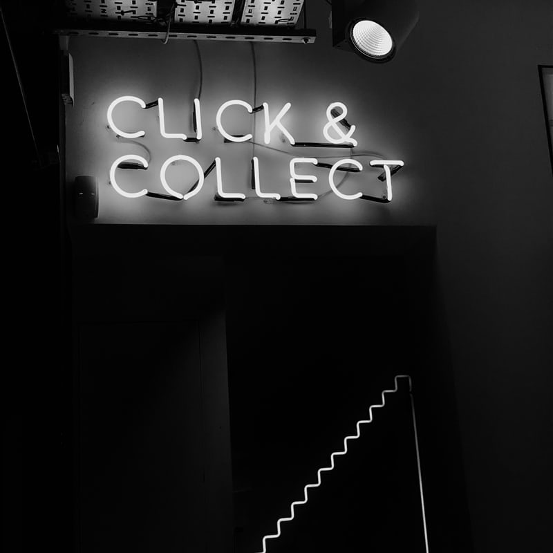 white neon sign that says click and collect