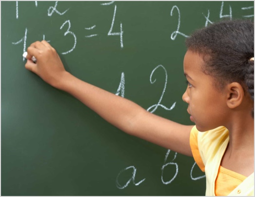 a girl writing numbers on chalk board