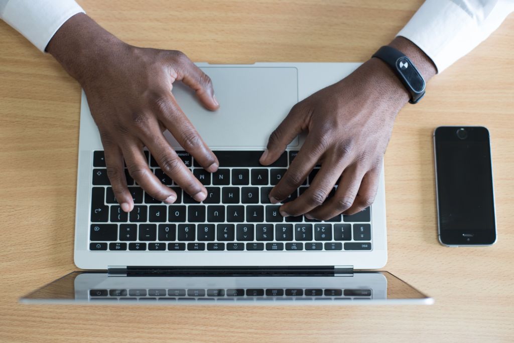 hands typing at a laptop