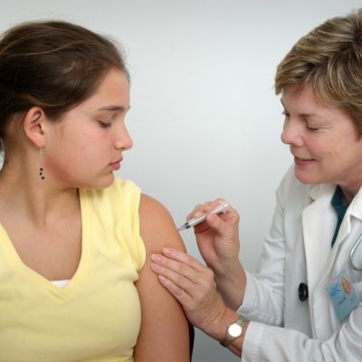 doctor giving a girl a vaccine