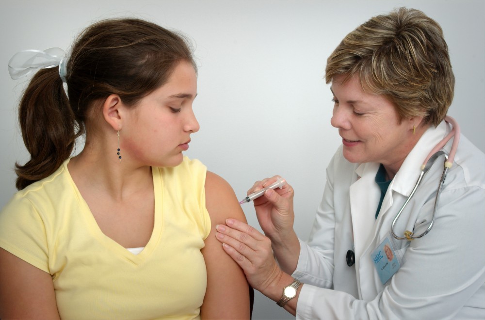 doctor giving a girl a vaccine