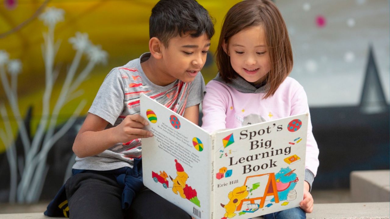 students reading a book together