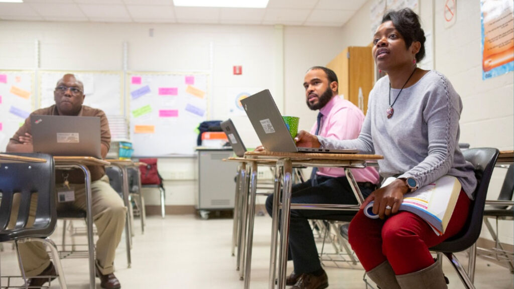 3 teachers sitting at desks