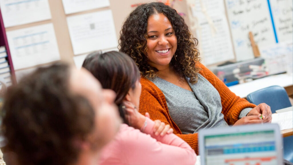 teacher smiling at 2 students