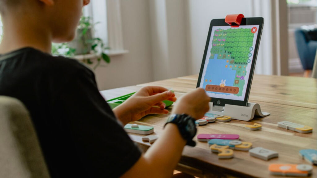 young boy playing a game on a tablet