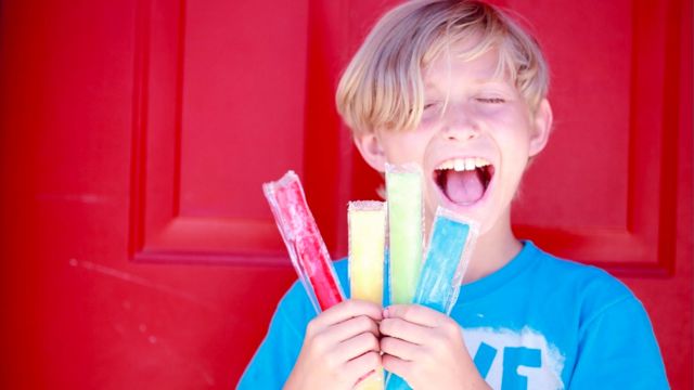 young boy holding freeze pops