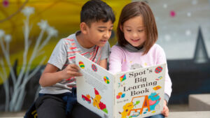 young children reading a book together