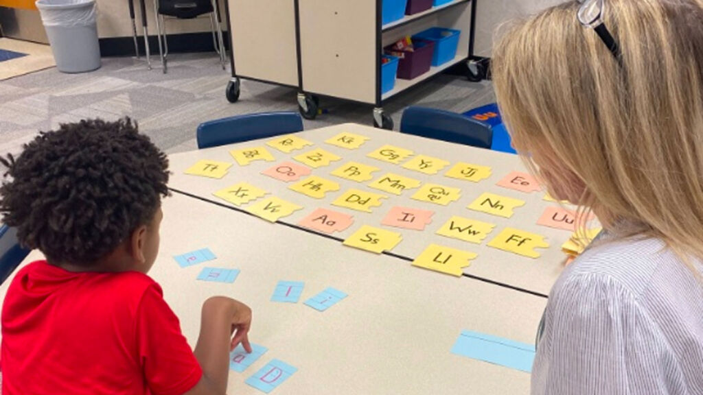 teacher and student working on flashcards