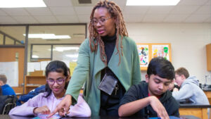 teacher helping students on their tablets