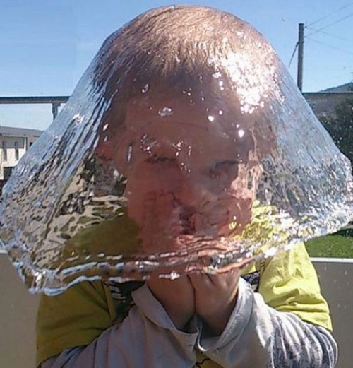 water crashing over boy's head