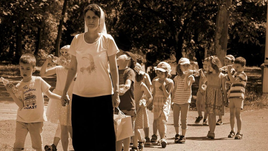 teacher walking in front of students in a line outside