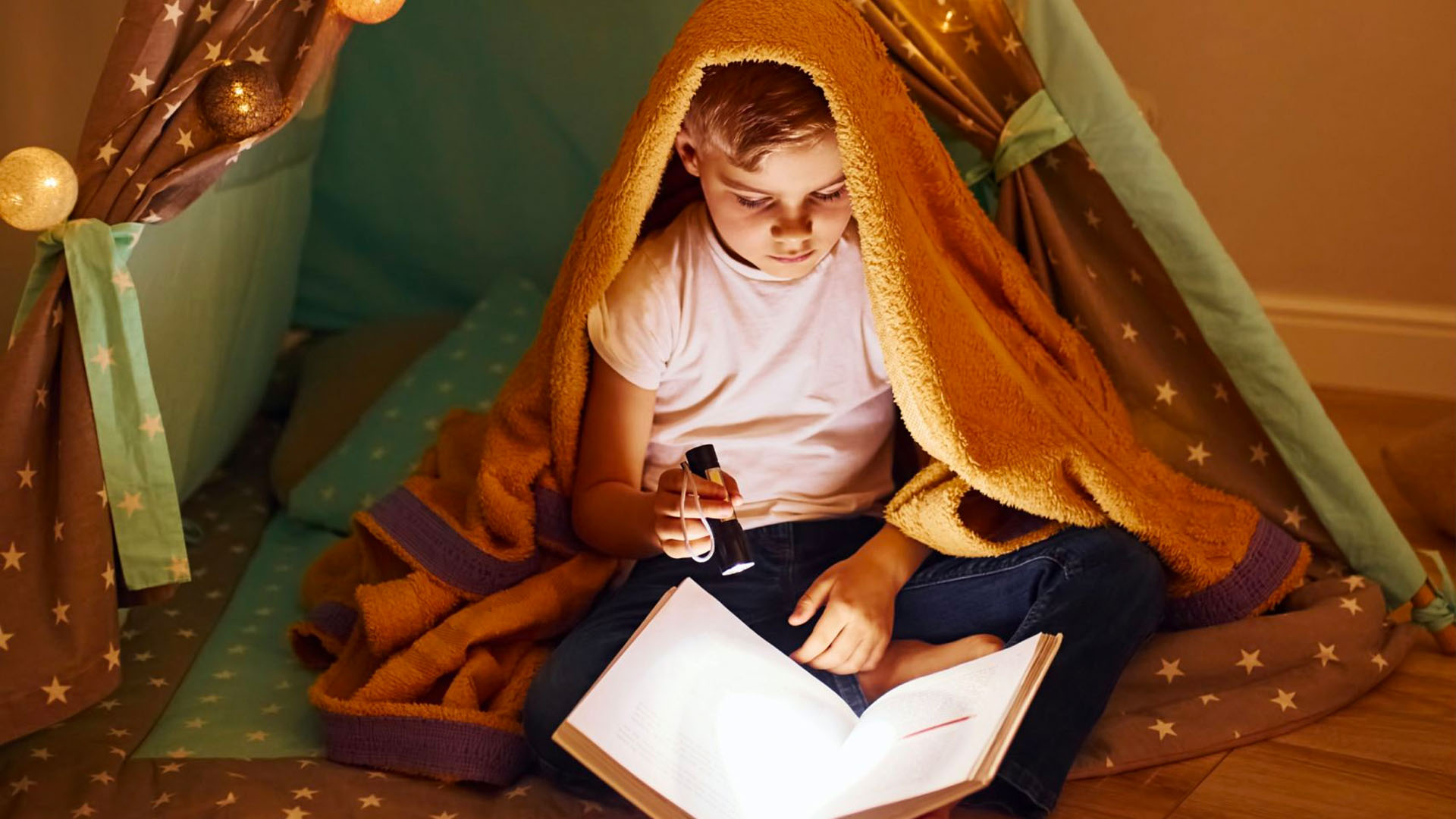 Child reading in a tent