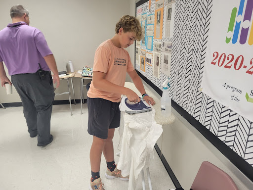 Student ironing a shirt.