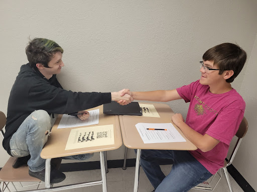 Two students shaking hands.