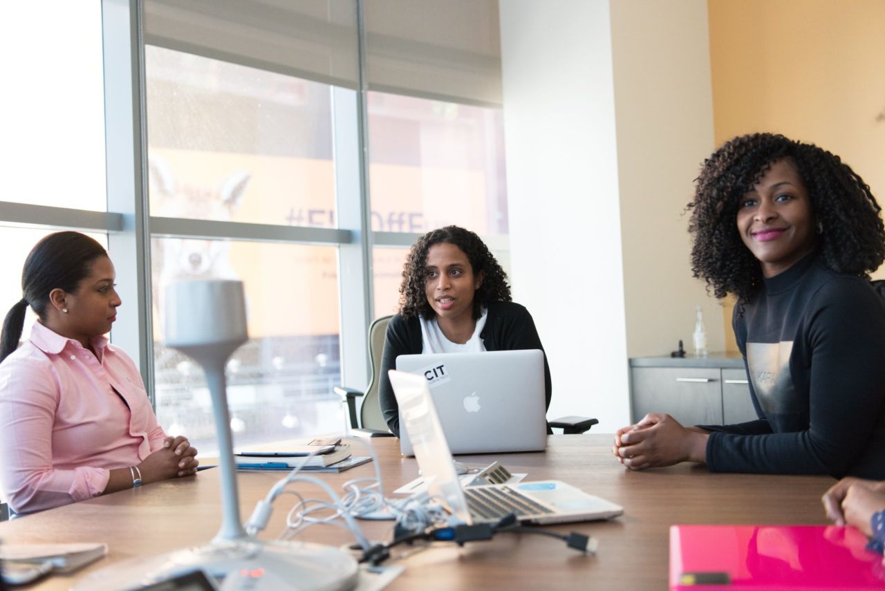 Women at a table with their computers.