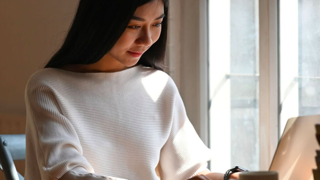 Woman working on a laptop at the table.