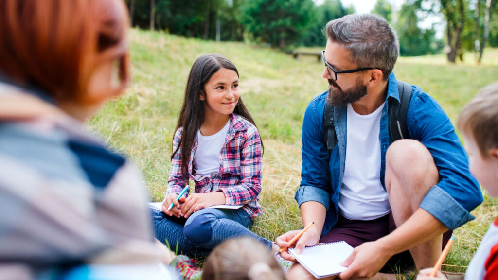 Teacher with students outdoors.