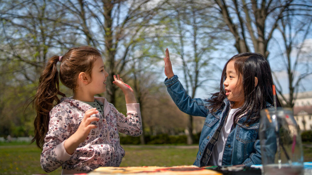 Two students high fiving.