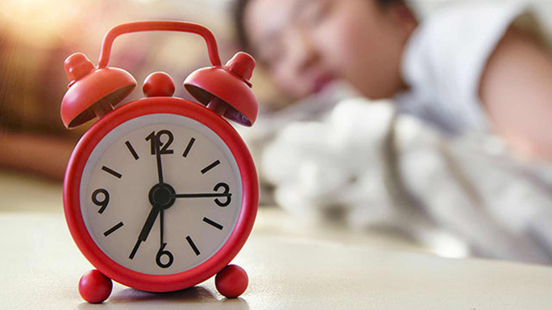 Student sleeping with an alarm clock.