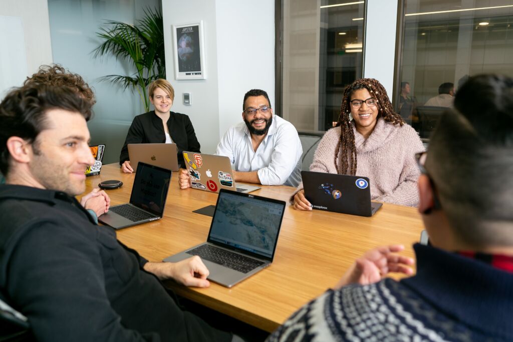 People sitting at a table with their laptops.