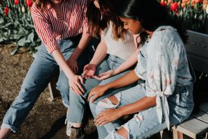 Three girls together, sitting on a bench.