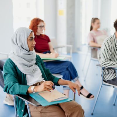 People sitting at desks in a classroom setting.