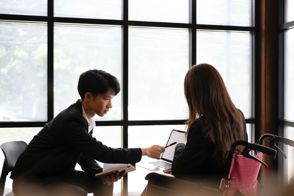 Two people going over content on a laptop.