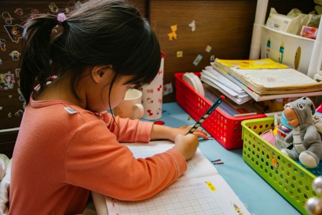 Little girl writing on paper.
