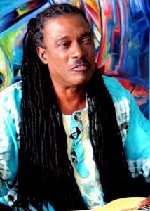 A man with locs posing for a picture.