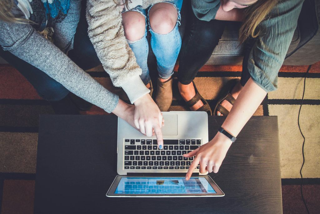 People pointing at a computer screen.