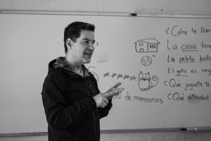 Man standing in front of a whiteboard, speaking.