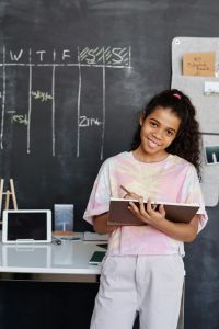 Girl posing for a photo in a classroom.