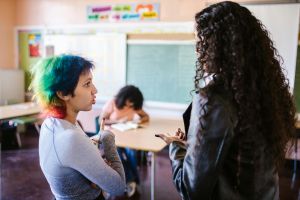 Two people talking in a classroom.