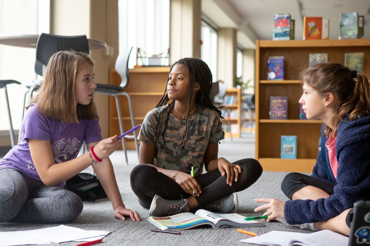 Seventh-graders work together on homework in their school library.