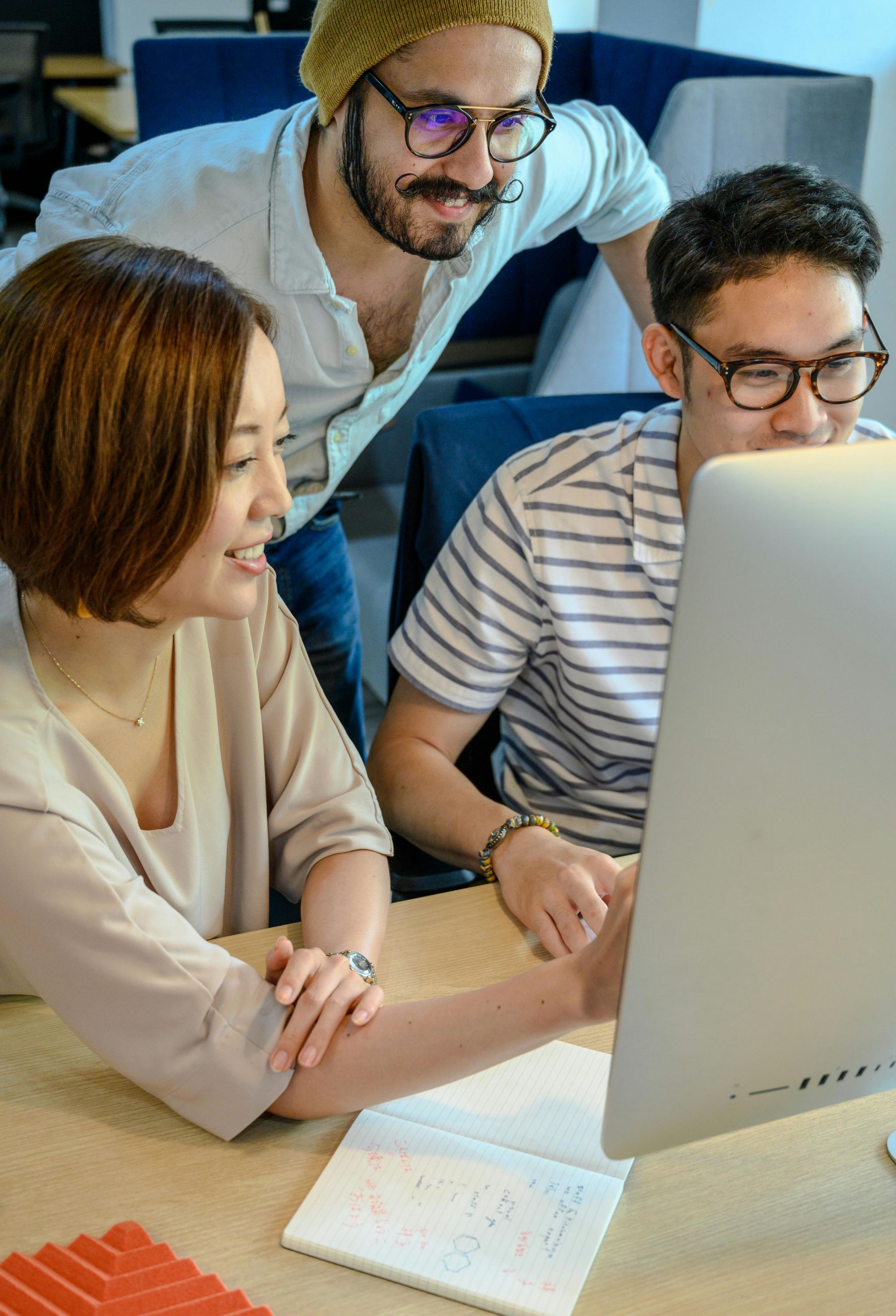 Three people looking at a monitor together.