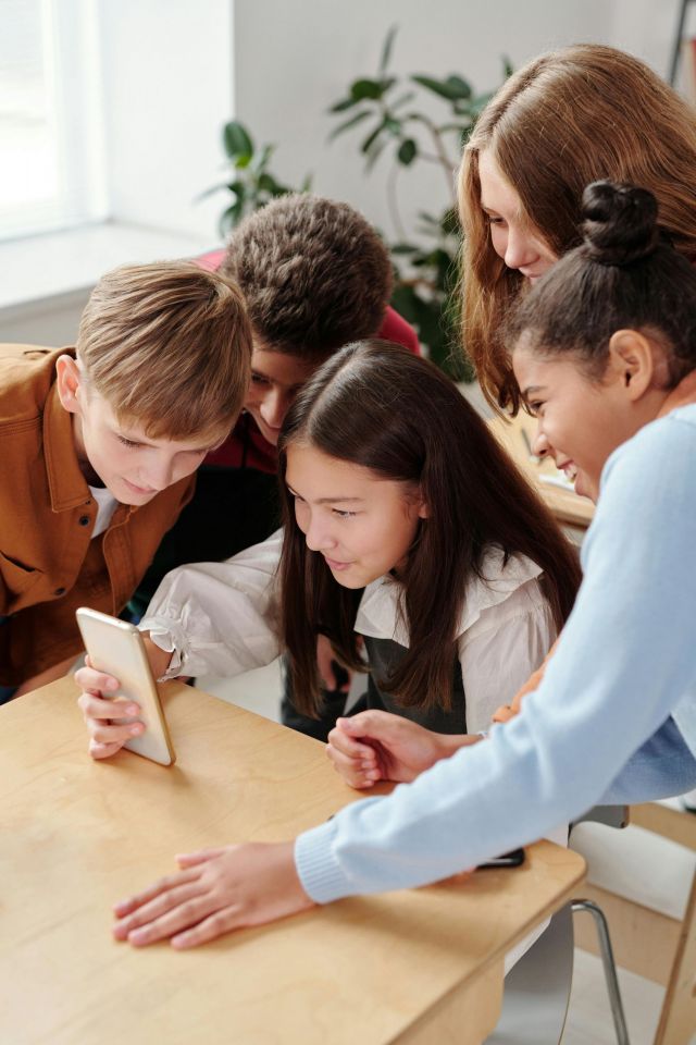 Students looking at a phone.