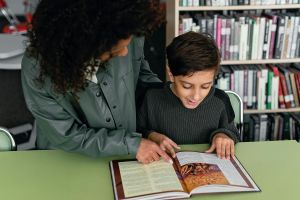 Teacher reading with a student.