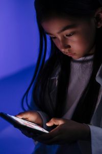 Student looking at an electronic device.